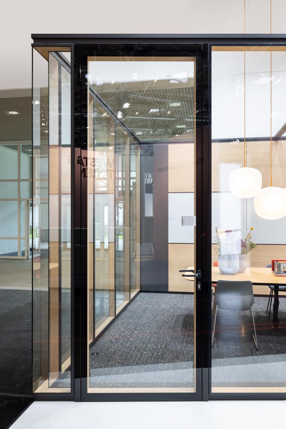 The natural wood surface in the 105-mm-thick glass wall creates a naturalistic atmosphere in sustainable office environments.