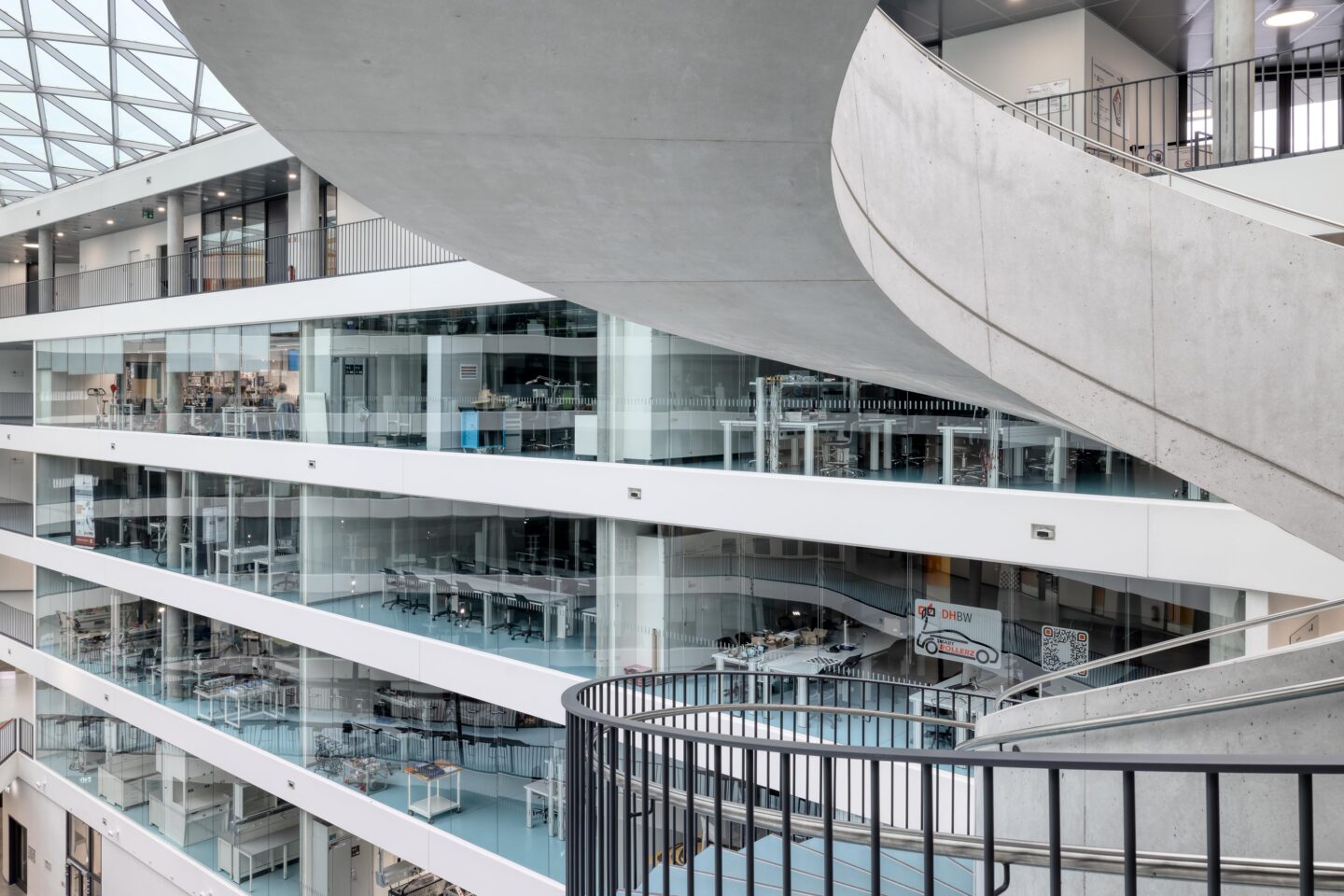 DHBW Stuttgart, Fakultät Technik | Blick vom Atrium vorbei an der Wendeltreppe auf die Glasfronten der Räume