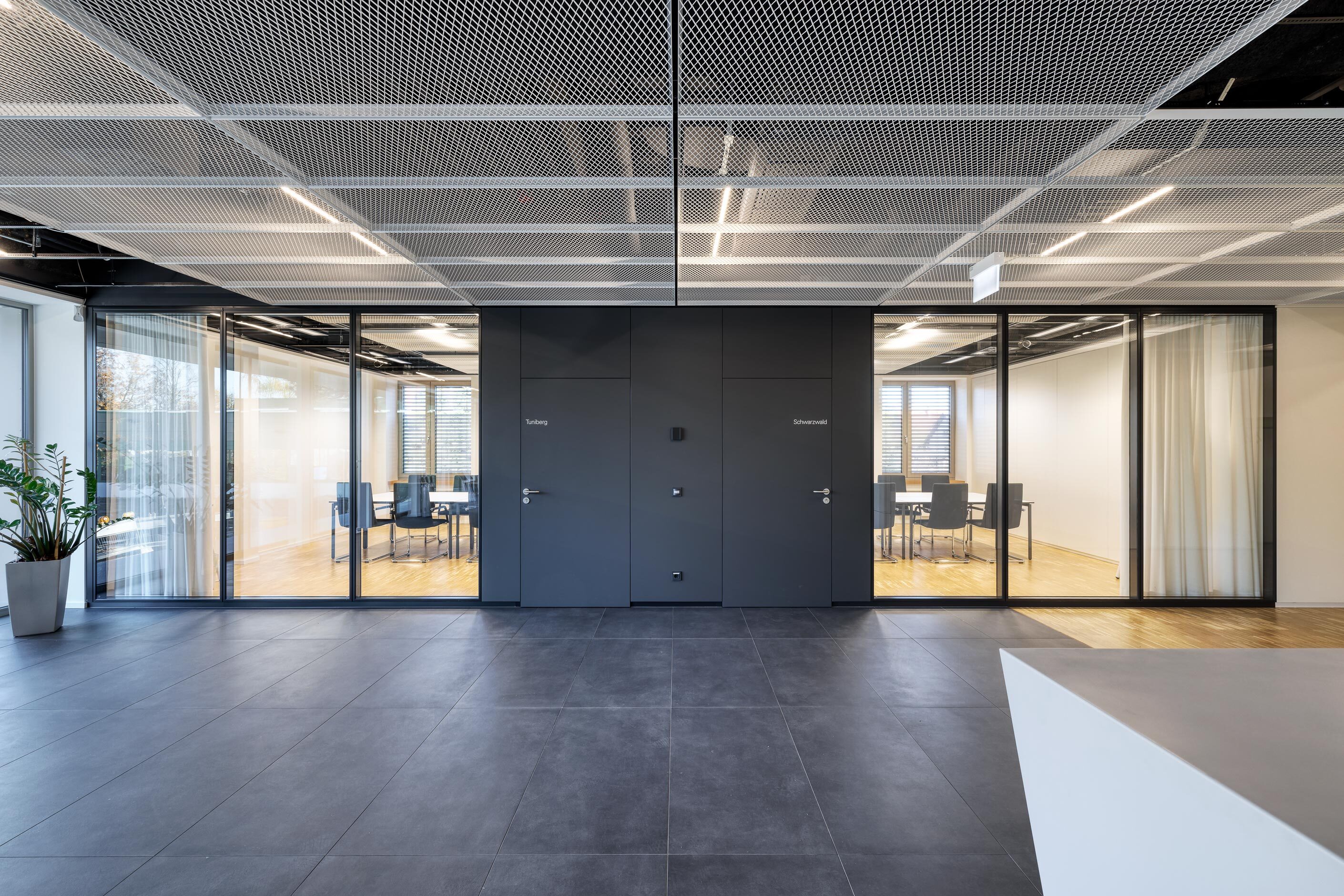 KNF Neuberger GmbH | grand space leading into office through glass wall and black doors
