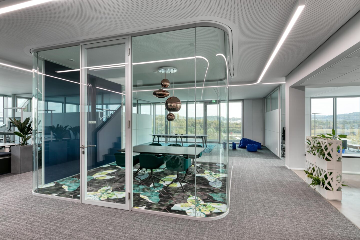Akustisch wirksamer Think Tank aus gebogenem Sicherheitsglas für ungestörte Meetings im Open-Space-Büro.