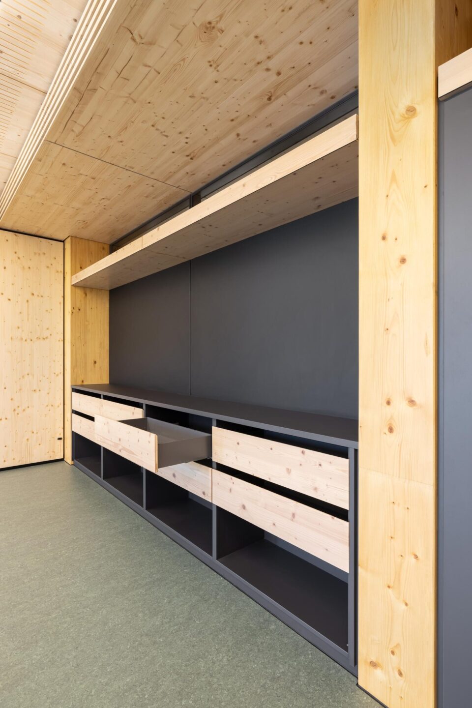 Detailed view of the feco cabinet unit with an open spruce wood drawer and dark interior structure.